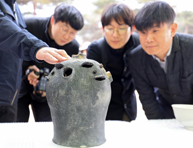与木简一起出土的人脸形状的陶器（韩国《每日新闻》）