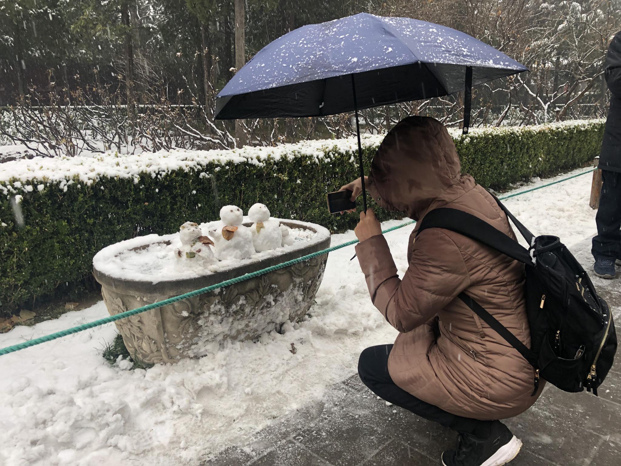 小雪人成“热宠”，游客们排队合影。新京报记者 张静姝 摄