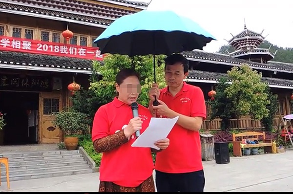 杜少平在同学聚会上为女同学打伞。视频截图