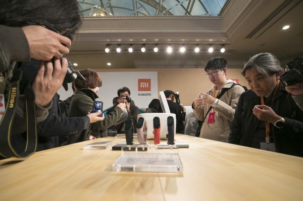  12月9日，在日本东京举行的小米公司发布会现场，嘉宾及媒体了解小米手环、智能电饭煲等产品。（新华社）