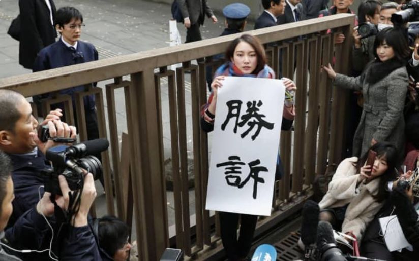 伊藤在法院门外举起写有“胜利”一词的标语。《日本时报》推特截图