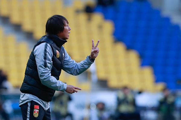 主教练李铁在场边指导。
