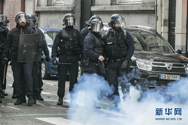  12月17日，在法国北部城市里尔，警察在示威游行现场警戒。新华社图