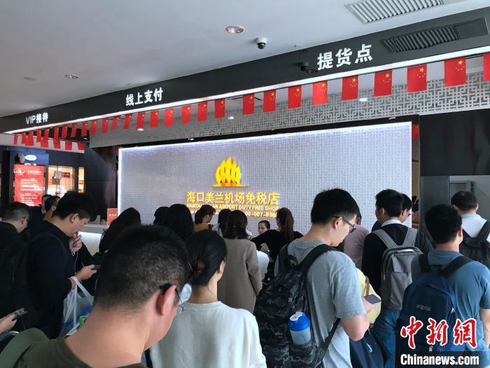 网购旅客在海口机场免税店提货点排队提货。 曾虹 摄