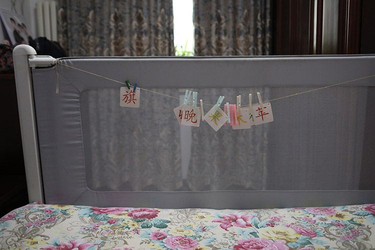  床头护栏上悬挂着张英女儿学习识字的字卡。