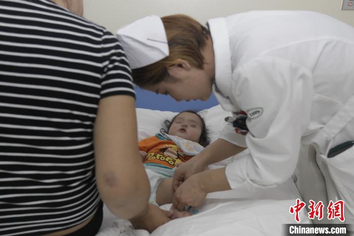 图为内蒙古人民医院的医护人员为患儿做检查。 俎怡然 摄