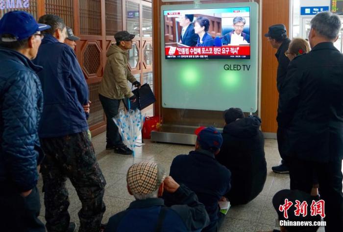 资料图片:2018年4月6日,韩国首尔火车站,人们观看韩国前总统朴槿惠案一审宣判的直播画面。 中新社记者 吴旭 摄