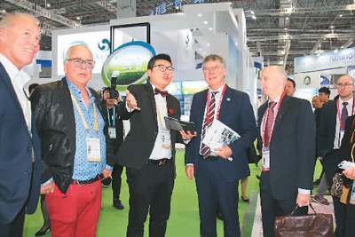 11月，王思维（左三）在第二届进博会现场为新西兰官员介绍展位情况。 王思维供图