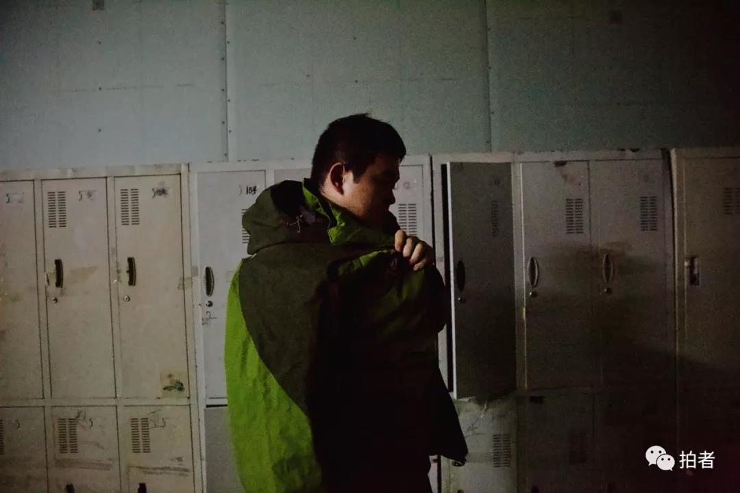 △12月19日,北京市顺义区牛栏山镇一工厂内,宇航下班后从自己的柜子里取出外套穿好。