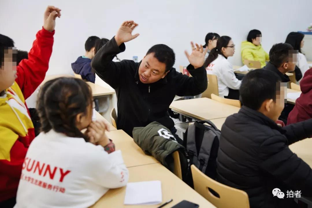 △12月7日,首都经贸大学,张弛在互动课堂上走了神,转身举手与身后的小伙伴互动。