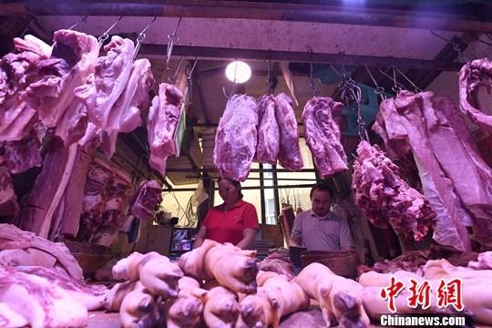 9月4日,重庆主城区的一家农贸市场内,商贩正在摆放猪肉。(资料图片)中新社记者 陈超 摄