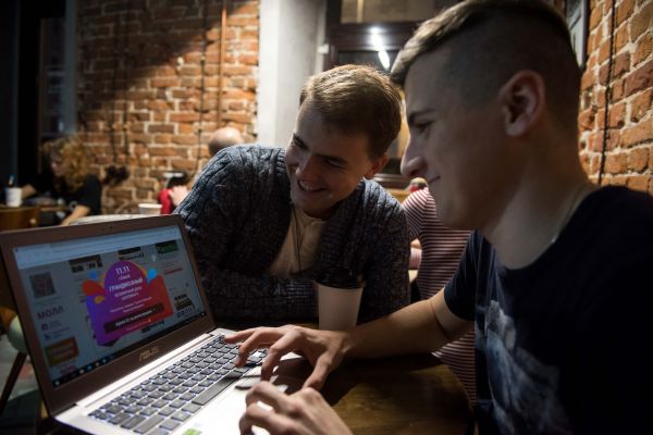 资料图片：俄罗斯首都莫斯科，两位年轻人正在速卖通平台查看“双十一”促销活动页面。（新华社发）