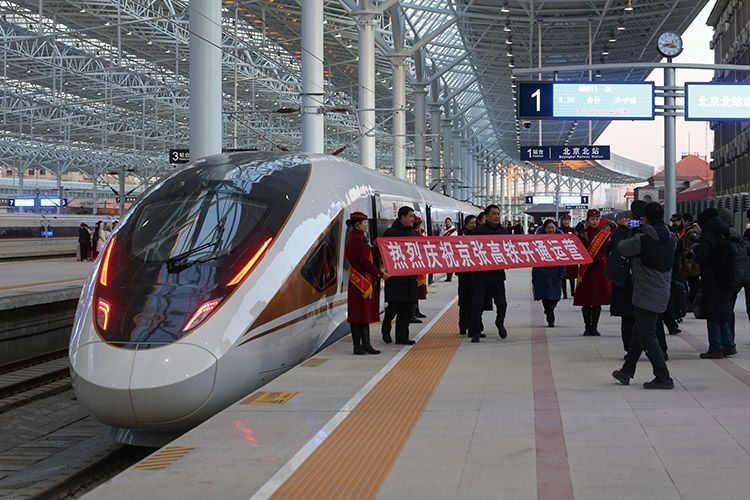  G8811高铁列车乘务人员打出“热烈庆祝京张高铁开通运营”的条幅。