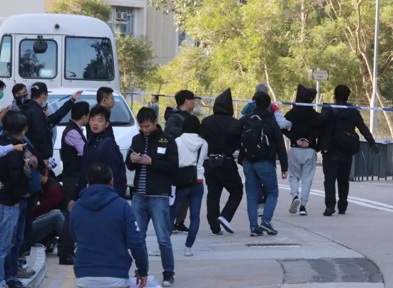 警方在行动中拘捕七人，疑犯被蒙头带返警署扣查。图片来源：大公报