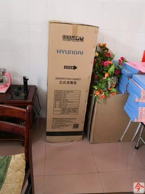 鹿寨县城镇幼儿园一办公室内，该县教育局用奖补资金采购后发给幼儿园的消毒柜和空调，因为没地方使用，至今未拆封。