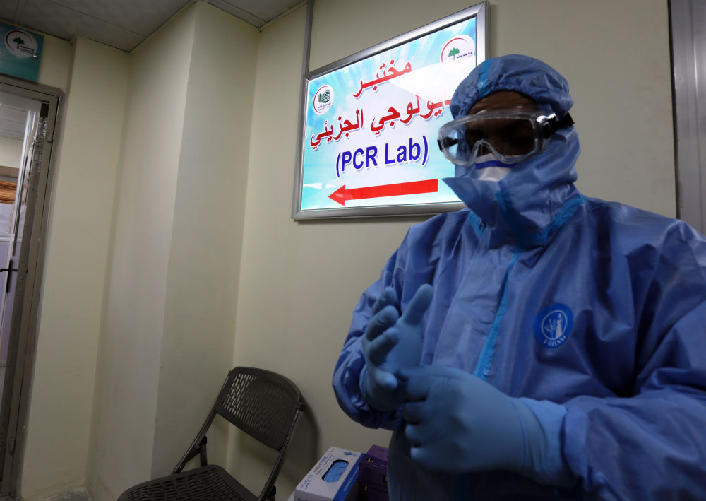 3月30日，在伊拉克巴格达，中国援建伊拉克的核酸检测实验室负责人穆罕默德·迈赫迪穿戴防护服准备工作。新华社发