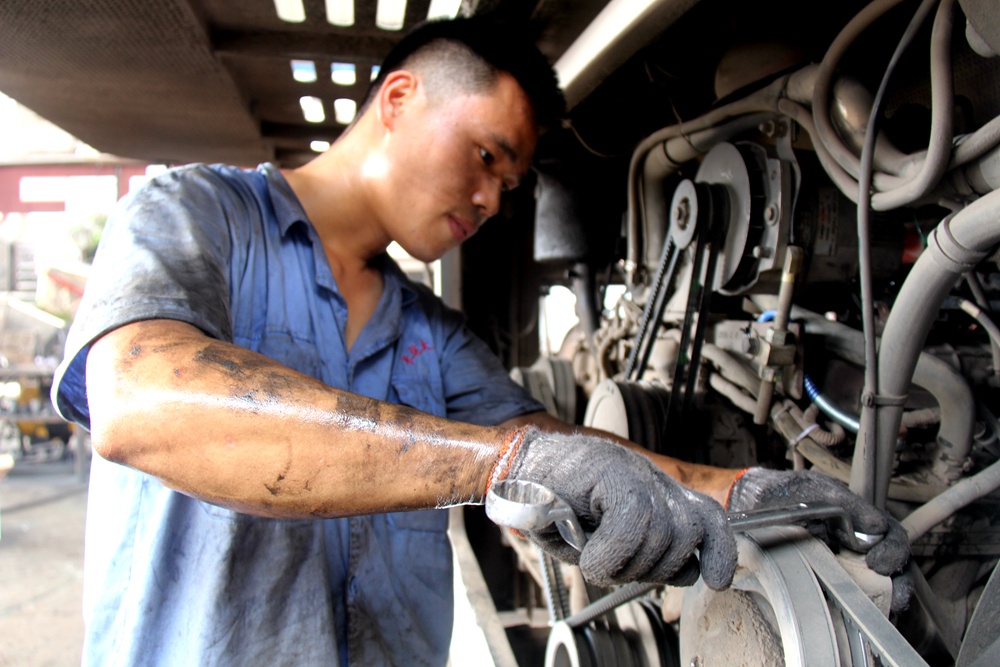重庆长运大足汽修工江怀学谭中勇不惧酷暑不顾油污为汽车疗伤治病图