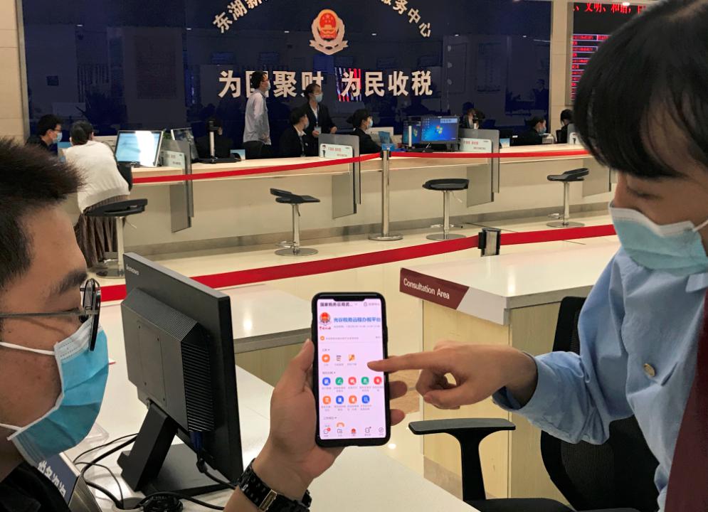 图为武汉税务干部在为纳税人介绍如何使用"光谷税务远程办税平台".