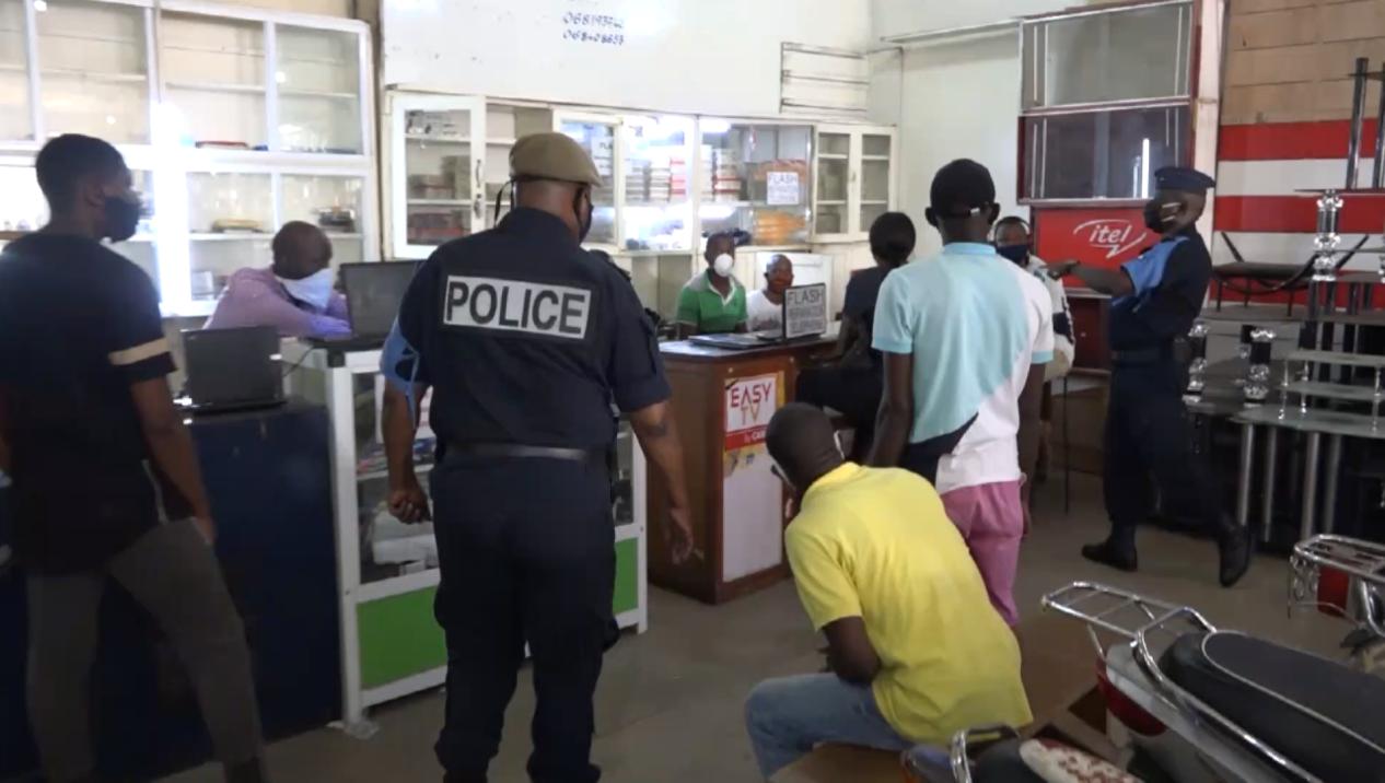 图为刚果(布)警察监督民众是否正确佩戴口罩