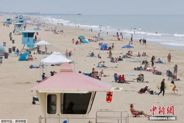 资料图：疫情之下，美国加州亨廷顿海滩游客兴致不减。