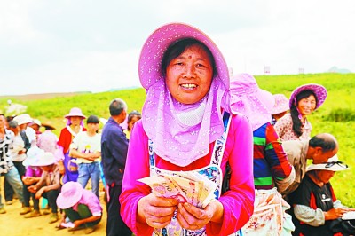     安顺市平坝区青庄坝区蔬菜种植基地的贫困务工人员领到工资。图片由青岛市扶贫协作办、安顺市扶贫办提供