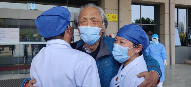 △4月9日,王欣老人痊愈出院,与医护人员深情相拥。