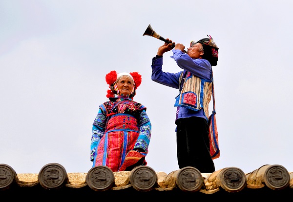 重阳节之际，泸西县一对盛装打扮的彝族“老夫妻”，聊起脱贫攻坚以来，农村发展条件和环境面貌发生的巨大变化，不由地吹响了唢呐。（康关福  摄）