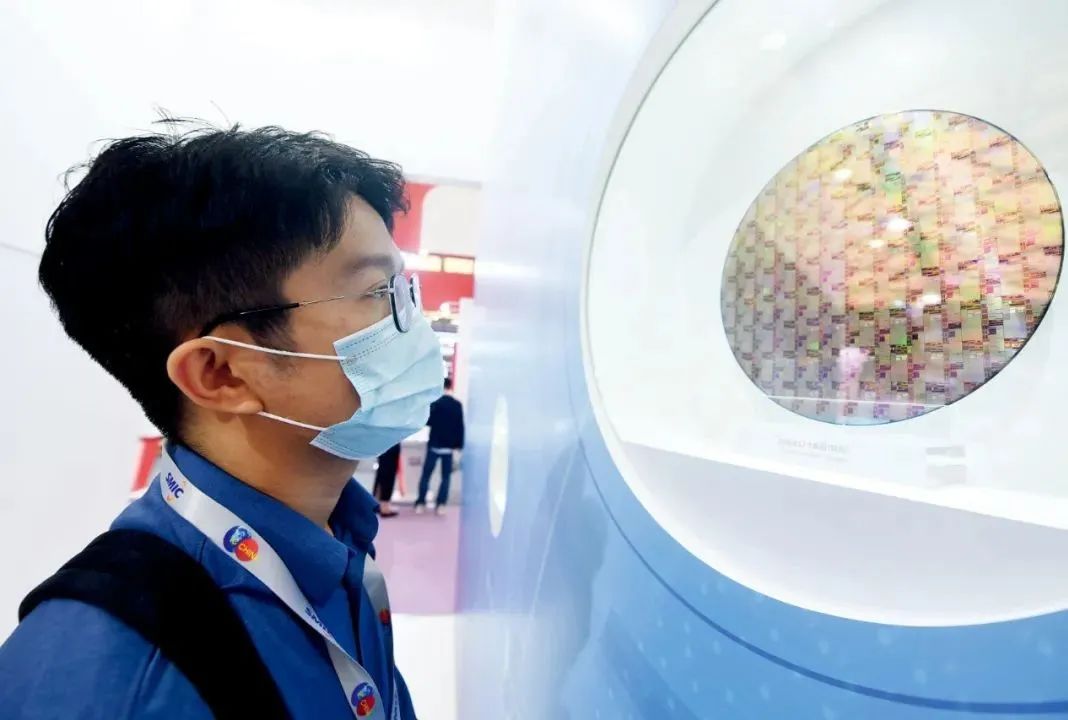 10月14日，参观者在2020中国国际半导体博览会上观看中芯国际代工生产的芯片。图/IC