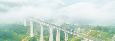  湖南省湘西土家族苗族自治州龙山县西湖冲特大桥上，云雾缭绕，一辆火车穿过云雾，飞驰而来，蔚为壮观。　　曾祥辉摄（人民视觉）