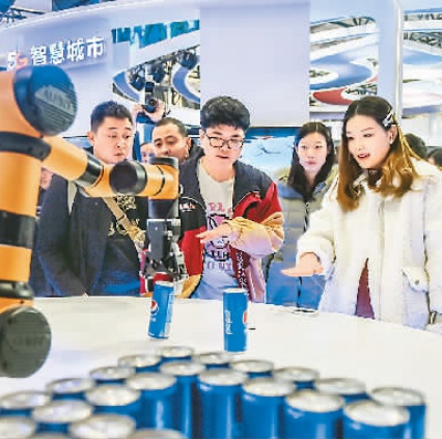  在北京市举行的2019世界5G大会上，参观者正控制机械臂抓取饮料，体验“隔空取物”。　　新华社记者 彭子洋摄