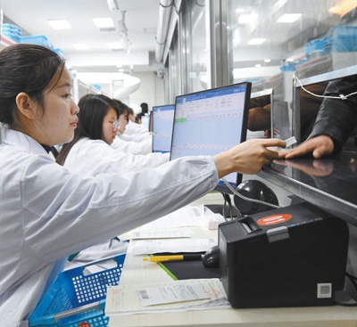 南昌大学第二附属医院的药房内，药师在给患者发放带量采购药品。