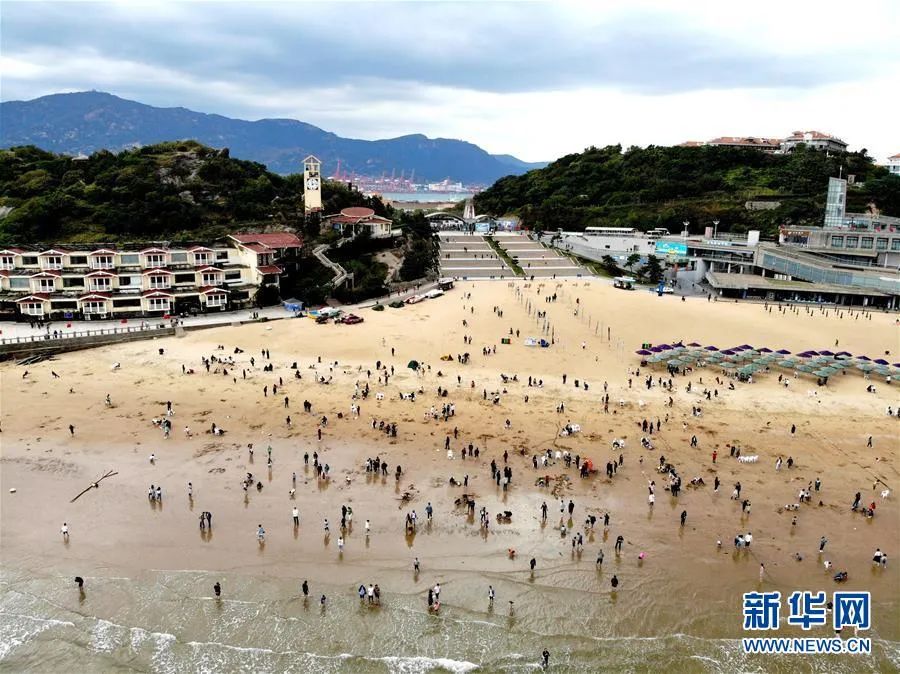 10月7日,游客在连云港市连岛大沙湾游乐园海滨浴场游玩(无人机照片)。新华社发(王春 摄)