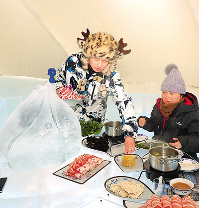 游客在哈尔滨冰雪大世界园区“冰屋”品味“冰火锅”。 　　原 勇摄（人民视觉）