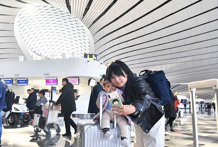 昨日,北京大兴国际机场,一名乘客在机场航站楼内和宝宝自拍.