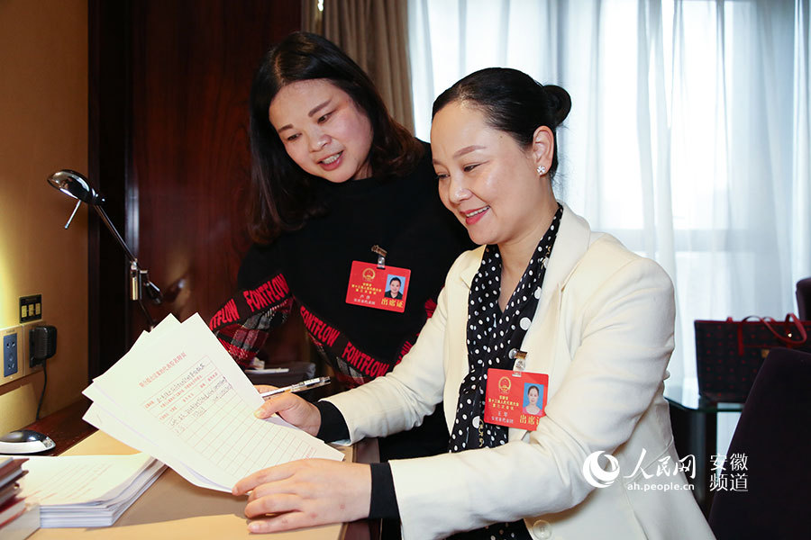 (图右)正与省人大代表,安庆市迎江区先锋社区党委书记卢萍讨论议案