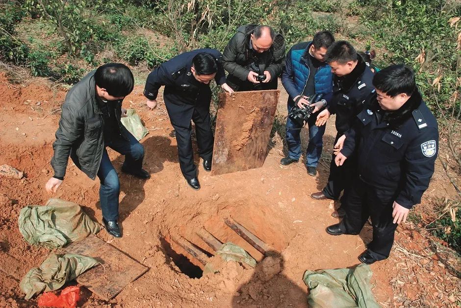 2014年3月,湖南常德临澧县公安局民警和临澧县文物局执法大队工作人员在被盗墓穴现场勘查。图/新华