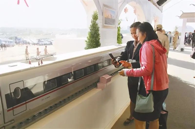 △中泰铁路合作项目一期工程开工仪式上，当地参观者拍摄中国“复兴号”高速列车模型