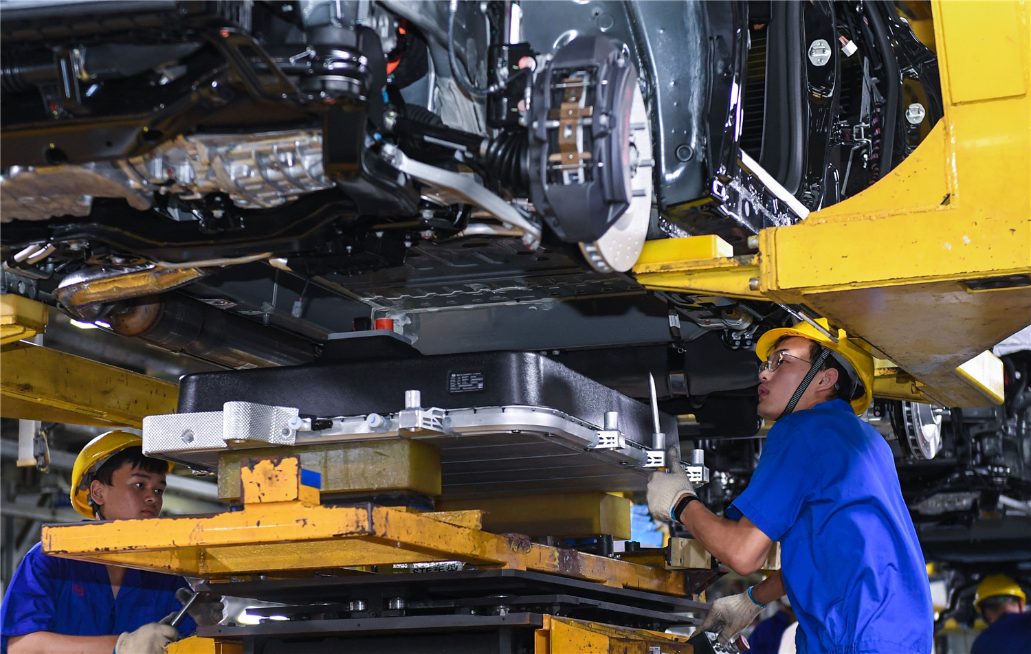 在深圳比亚迪总部,工人为新能源汽车安装电池.新华社记者 毛思倩 摄