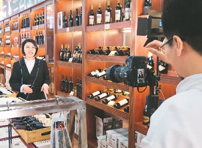 浙江省丽水市青田县进口商品城的进口红酒销售商录制视频准备在线上销售平台进行推广。新华社记者 徐 昱摄
