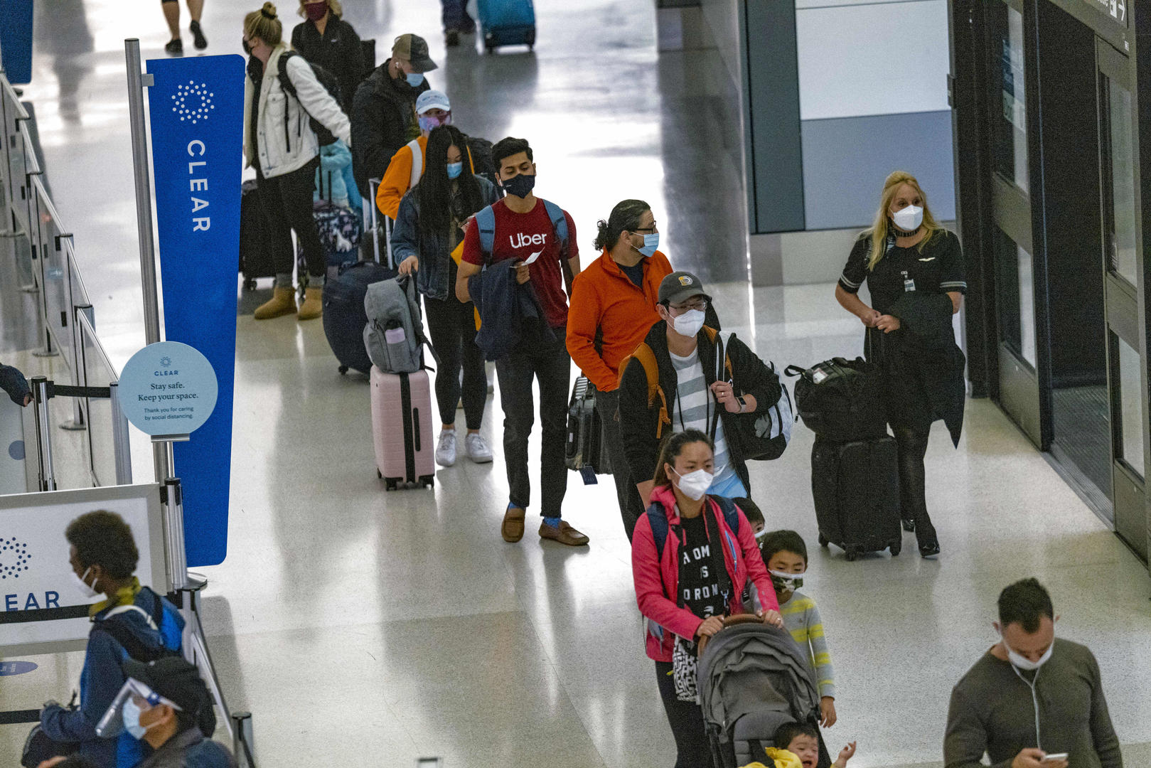 ▲当地时间24日，洛杉矶国际机场排队等待安检的旅客。图据CNBC