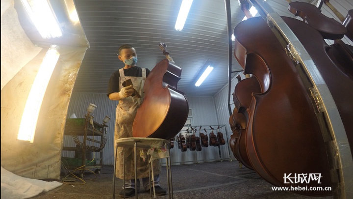黄国权在钻研小提琴的喷漆技术。长城网记者 马宁 摄