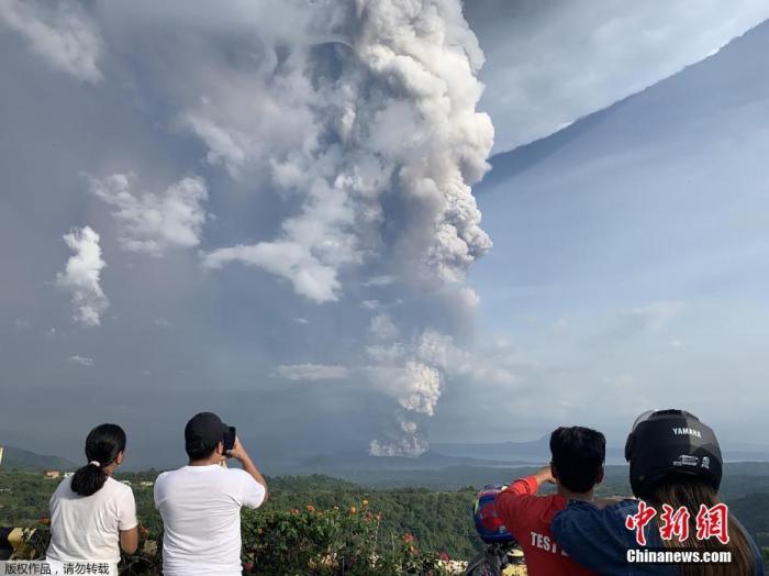 资料图:当地时间1月12日,菲律宾马尼拉西南卡维特省的塔盖泰镇,民众在给爆发的火山拍照。当地时间12日,菲律宾旅游胜地大雅台附近的塔尔火山开始喷发,火山灰高达10至15公里。