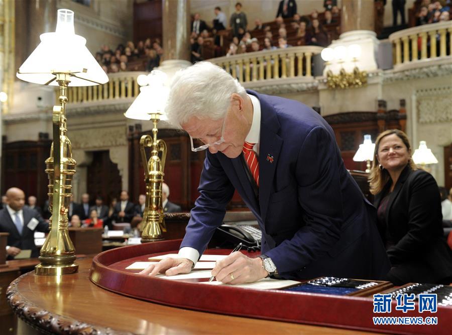 2016年12月19日，在美国纽约州奥尔巴尼，美国前总统、纽约州选举人比尔·克林顿在投票后签署文件。