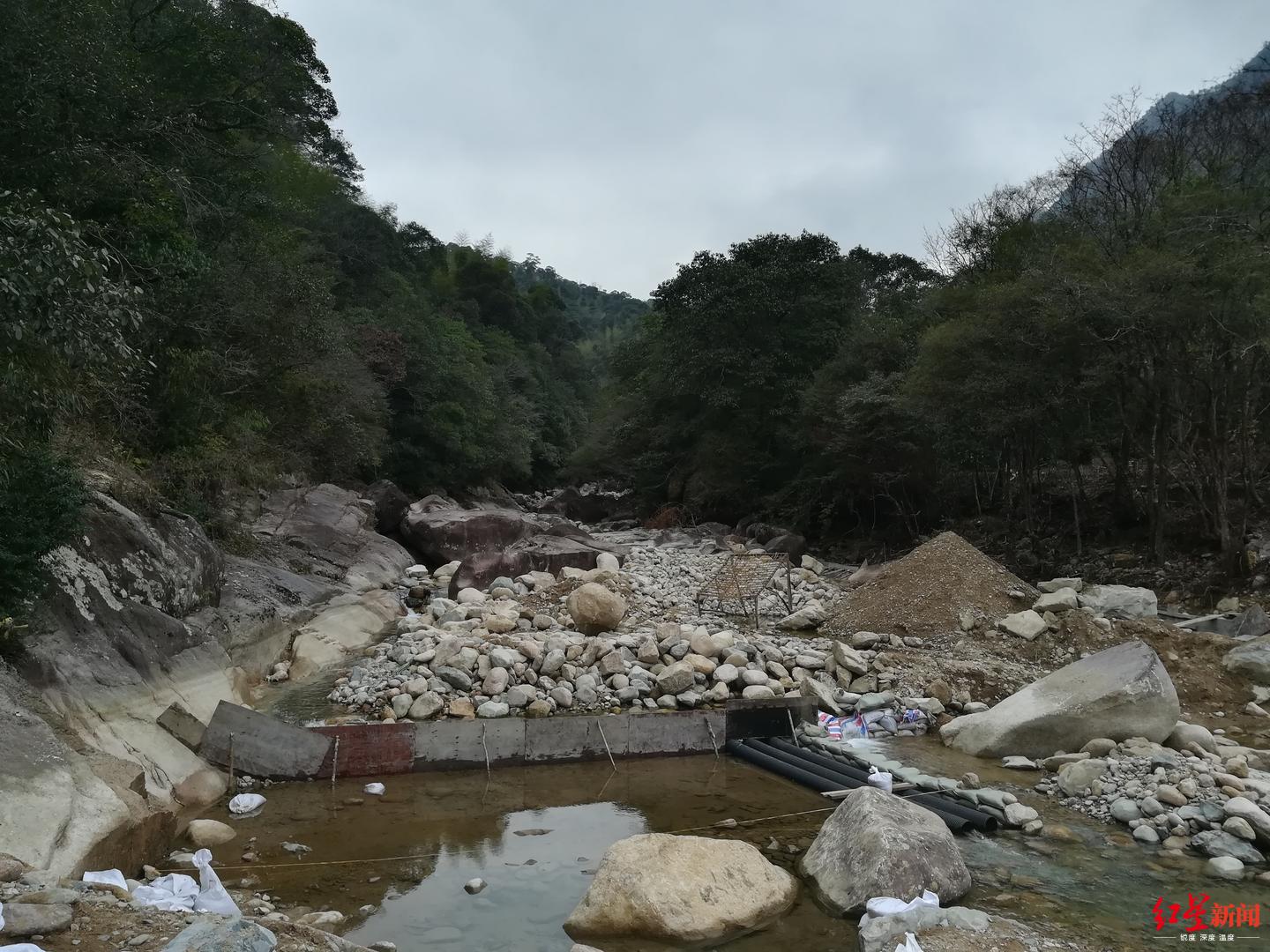 ↑武夷山农夫山泉拟建堤坝处堆放着少许建筑材料。