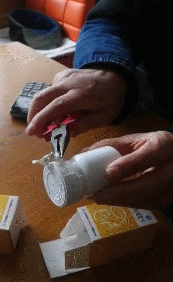 双手紧握瓶身瓶盖,眉头皱起,两膀用力,憋得脸都红了,没拧开