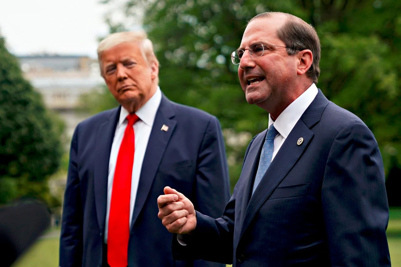 △美国卫生与公众服务部部长亚历克斯·阿扎（右）在白宫南草坪上向媒体发表讲话，美国总统特朗普站在一旁。