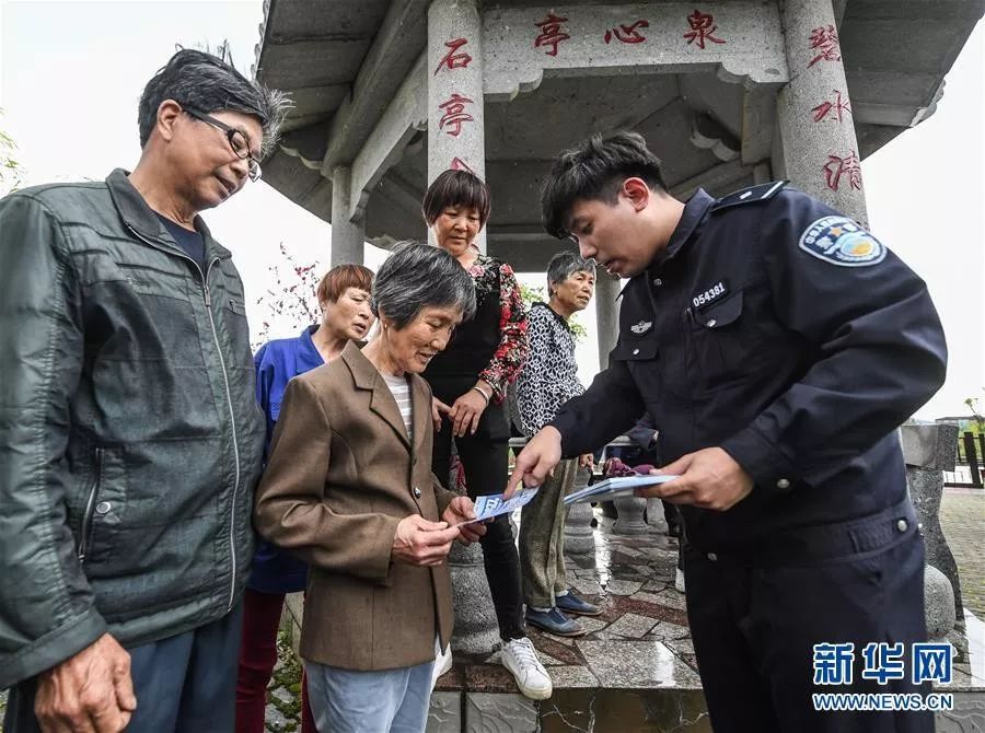2019年4月9日,浙江省湖州市吴兴区东林镇派出所的民警在泉心村向百姓发放“扫黑除恶”宣传资料。 新华社发