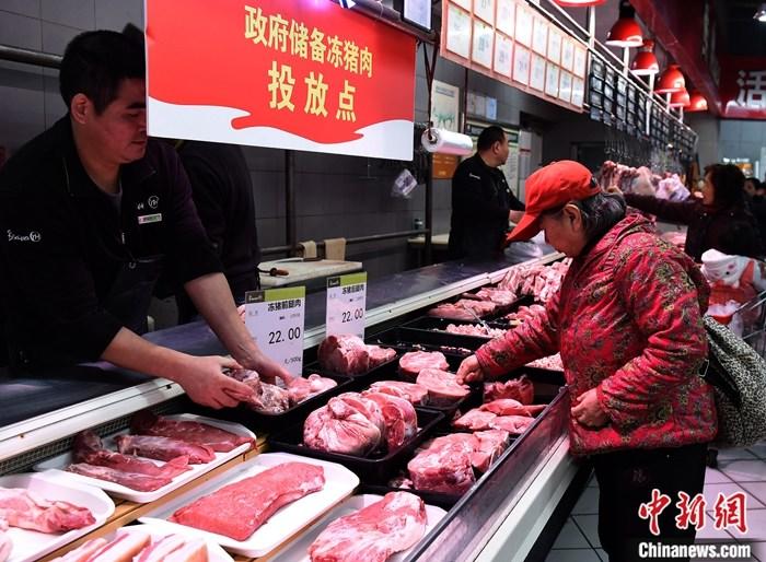 资料图：重庆市市民在一家超市选购市政府投放的储备冻猪肉。中新社记者 周毅 摄