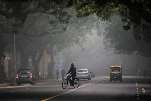  图为2019年12月30日，在印度首都新德里，一名男子在浓雾中骑行。新华社/法新