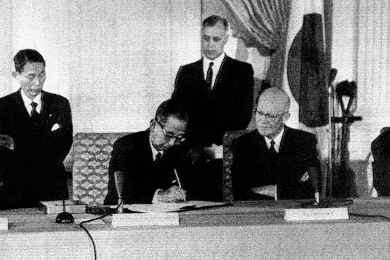 时任日本首相岸信介在美国总统艾森豪威尔注视下签字（图/AP）